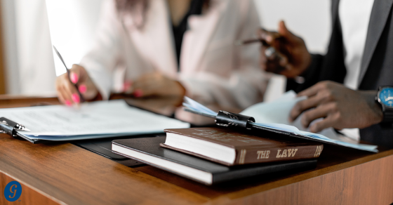 table with book that says The Law and two people sitting behind the table and conversing OBBBA tax changes for business