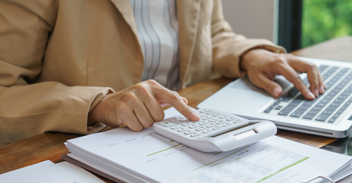 person at a desk using a calculator Understanding the Qualified Business Income Deduction QBI