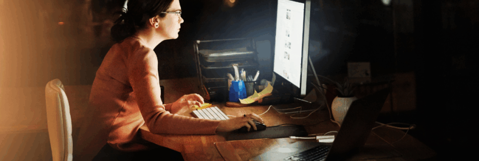 woman working at desk with computer in the nighttime Managing Overtime Costs Without Sacrificing Productivity