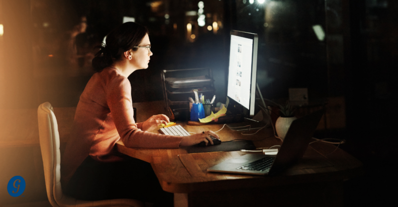 woman working at desk with computer in the nighttime Managing Overtime Costs Without Sacrificing Productivity