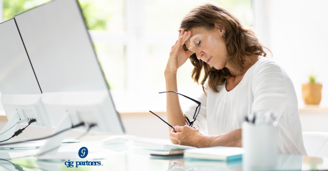 woman at a desk looking stressed out and holding her glasses with her head propped on her hand Post-Tax Season Bookkeeping Fix What Went Wrong Now cjg partners accounting cpa