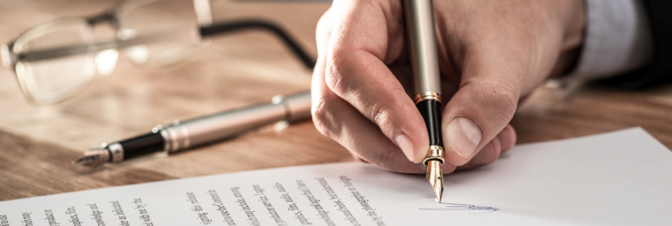 hand signing a document with a pair of glasses next to it What Your Audit Is Really Worth (Hint: It's More Than Compliance) CJG Partners