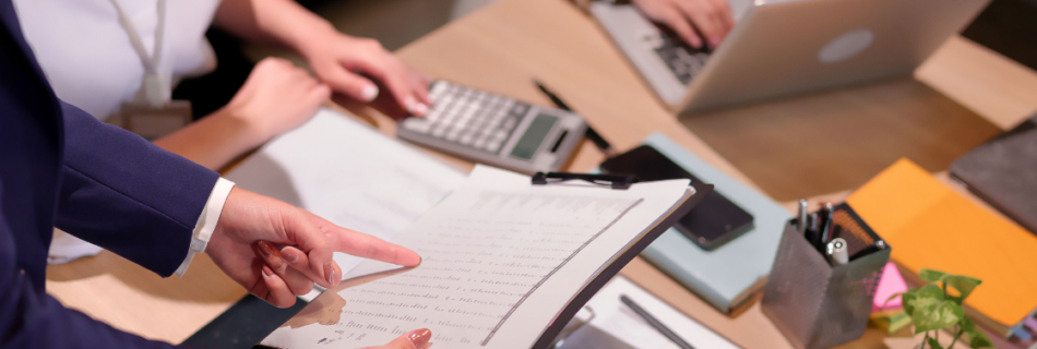 people at a conference table looking at documents audit review and compilation Schaumburg Audit, Review, and Compilation Services for Schaumburg Area Businesses: Which One Do You Need