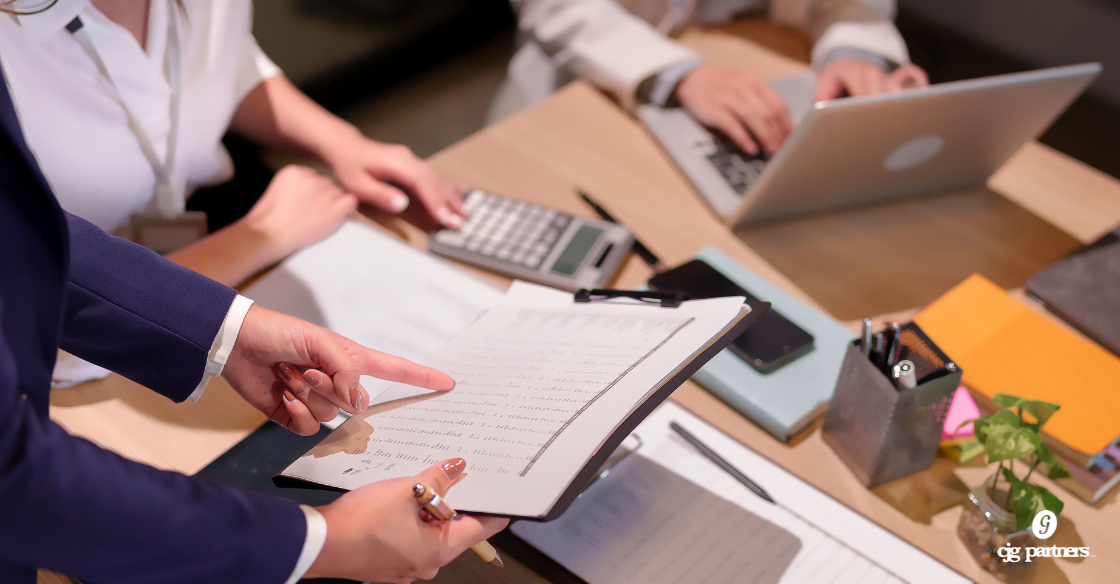 people at a conference table looking at documents audit review and compilation Schaumburg Audit, Review, and Compilation Services for Schaumburg Area Businesses: Which One Do You Need