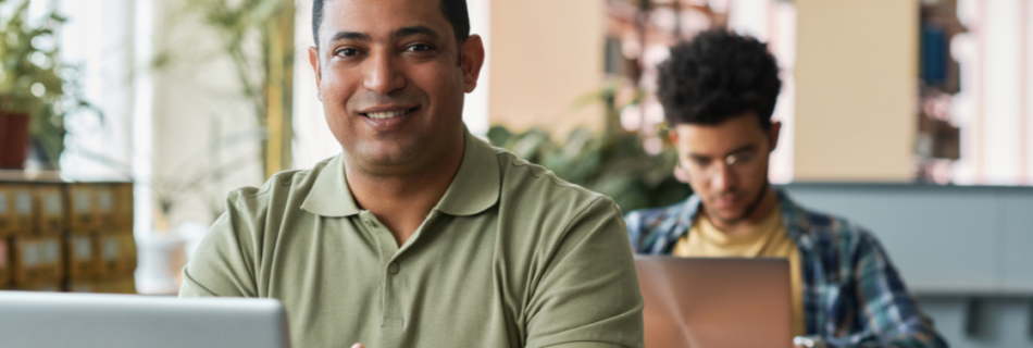 older student sitting at a desk with a younger student sitting at a desk behind him How a Section 127 Educational Assistance Plan Benefits Your Business and Your Team cjg partners