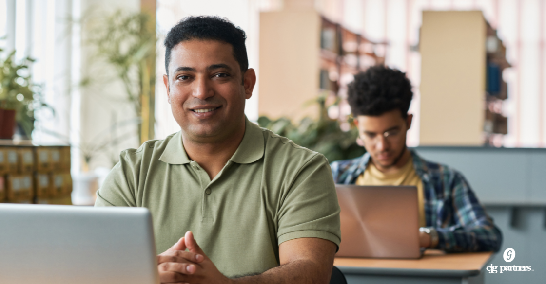 older student sitting at a desk with a younger student sitting at a desk behind him How a Section 127 Educational Assistance Plan Benefits Your Business and Your Team cjg partners