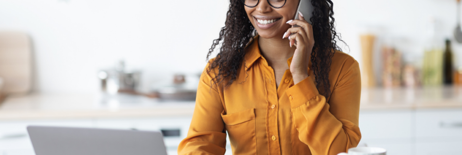 woman sitting at a table typing on a laptop and talking on a cell phone Hiring Independent Contractors? Get the Worker Classification Right cjg partners