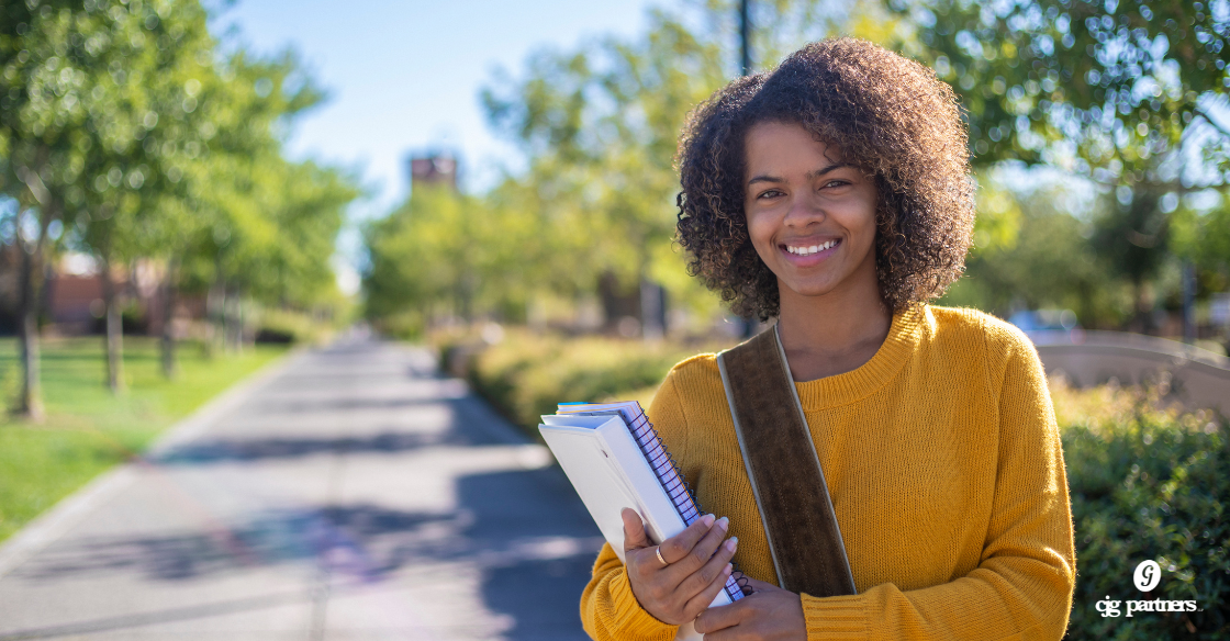 young black woman standing outside with a bookbag on her shoulder and holding a binder and a notebook Does College Financial Aid Count as Taxable Income?